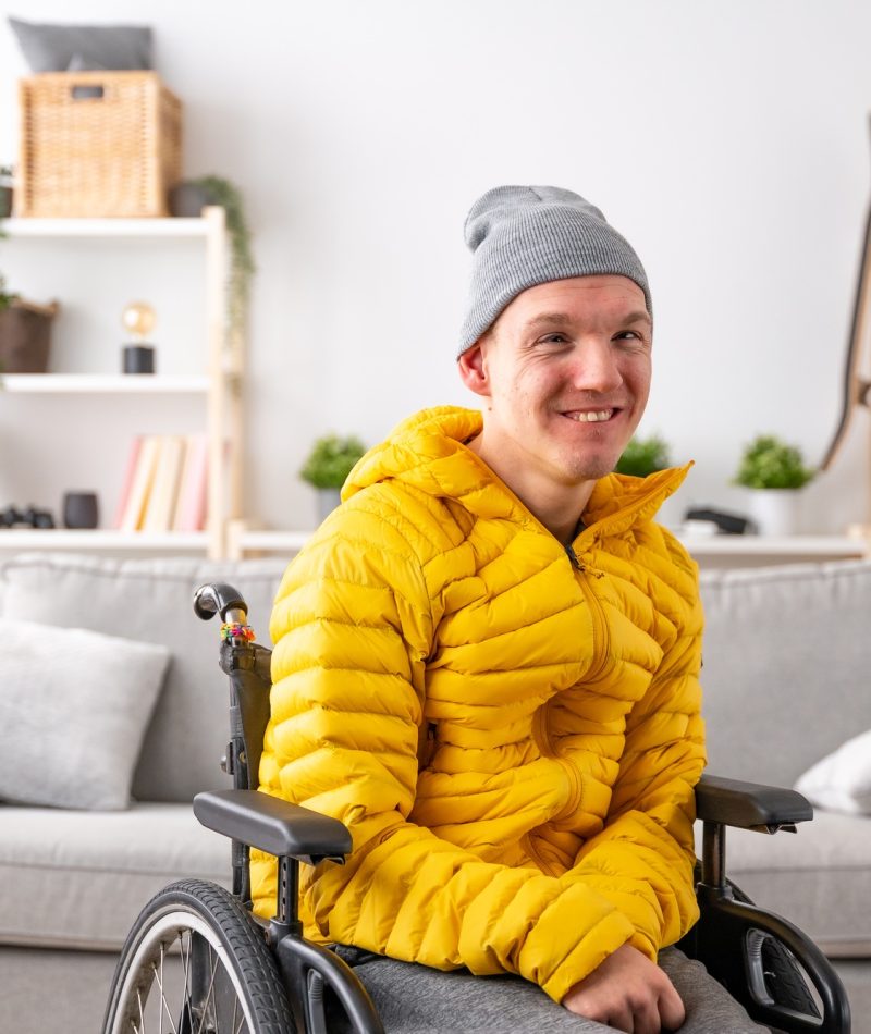 Smiling man with special needs in wheelchair at home